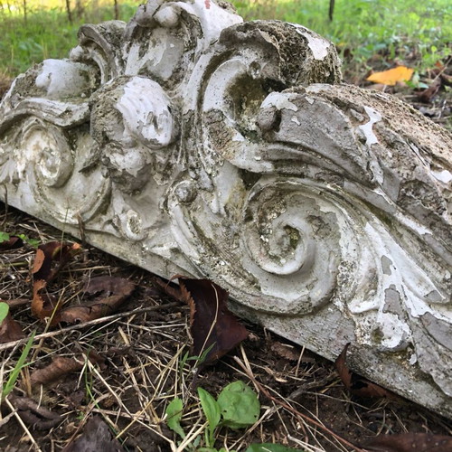 Old plaster pediment used with spiral motifs and human head