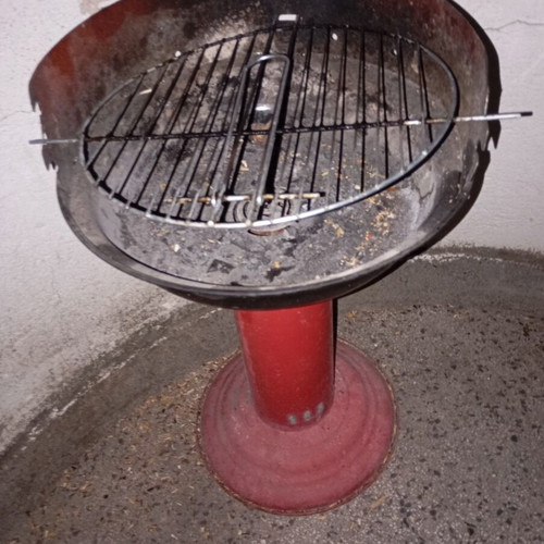 Portable vintage charcoal barbecue with red central leg, used