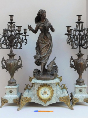 Metal clock with girl and dog statues, marble base and candelabras