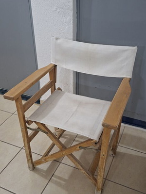 Classic wooden director's chair with folding frame and canvas back