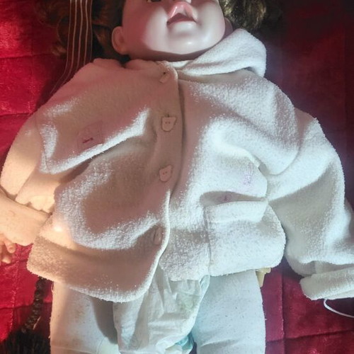 Vintage collectible baby doll with porcelain head and glass eyes