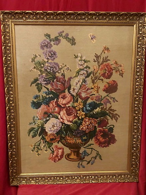 Cross-stitch embroidery used in vintage carved wooden frame with glass