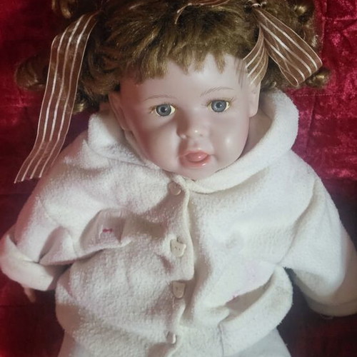 Vintage collectible baby doll with porcelain head and glass eyes