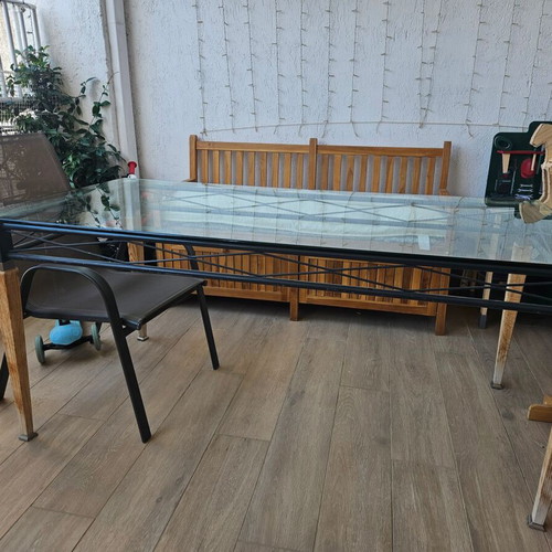 Garden table used with wooden legs, metal base and glass top