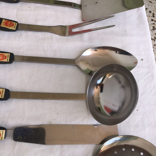 Vintage stainless steel kitchen tool set with black handles and wall rack