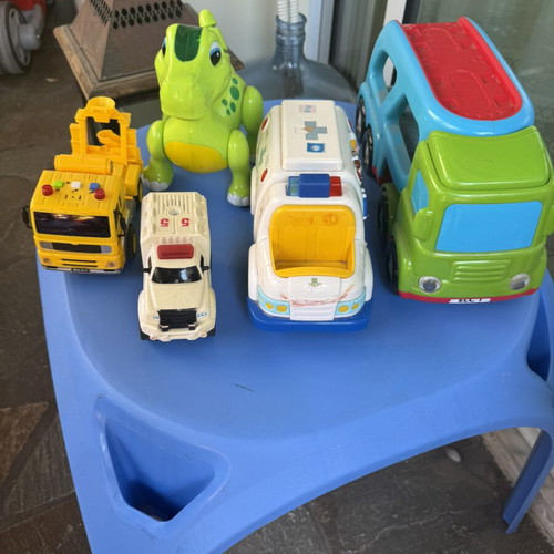 Various toys including vehicles and dinosaur