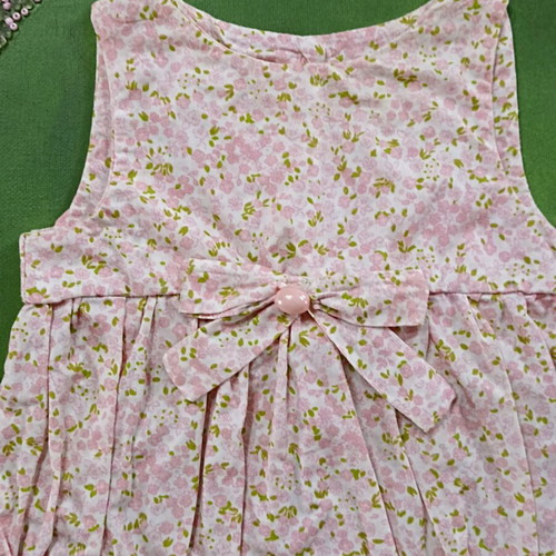 Handmade canvas frame with baby romper, pink flowers, beads, and lace