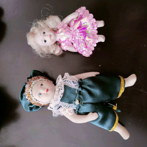 Porcelain dolls like new, set with one broken arm
