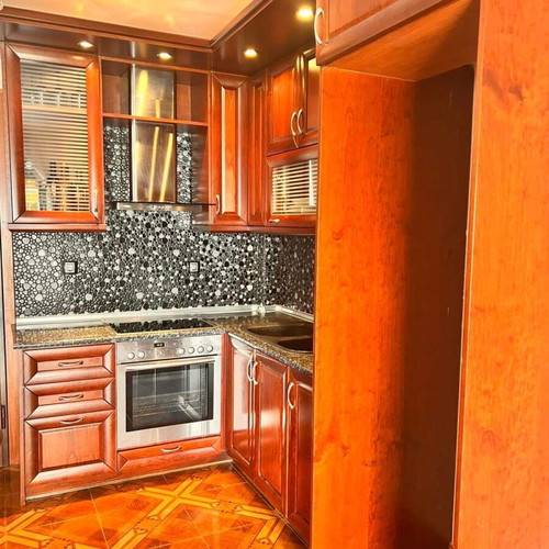 Corner kitchen made of solid cherry wood with extractor hood used