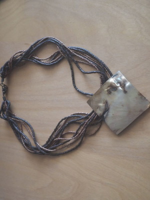 Necklace with large mother-of-pearl plate and beads