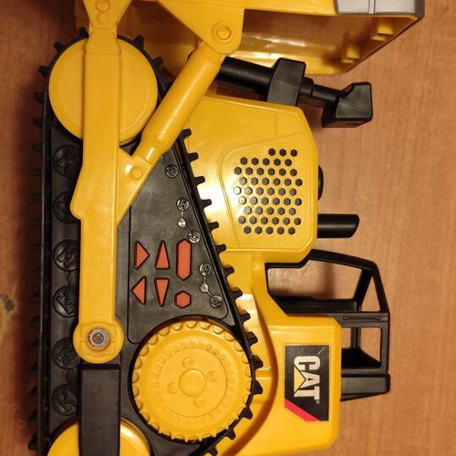CAT bulldozer toy used with moving tracks and gradual forward-back motion