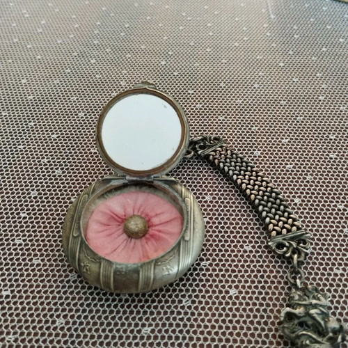 Silver powder compact used, 1880 era with chain and embossed figures