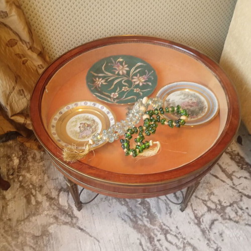 Round showcase table with carved brass legs