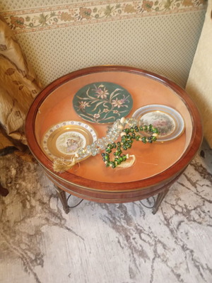 Round showcase table with carved brass legs
