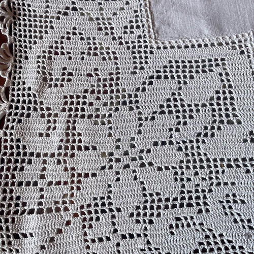 White embroidered tablecloth used on linen fabric with lace