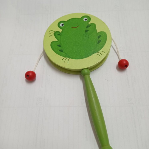 Wooden musical instrument drum with green frog used