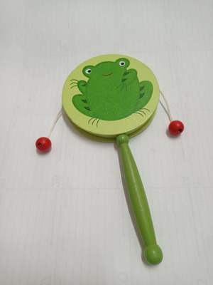 Wooden musical instrument drum with green frog used