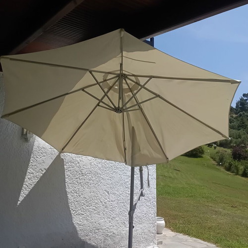 Garden umbrella used, white fabric with support plates