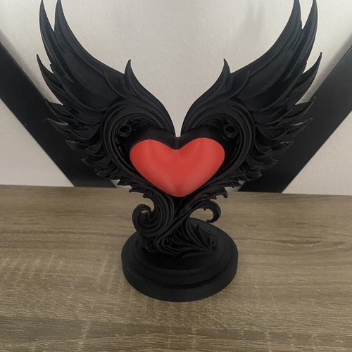 Decorative sculpture with black wings and red heart, new