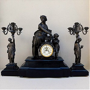 Ρολόι μεταλλικό με αγάλματα Αφροδίτης και Έρωτα, μαρμάρινη βάση και δυο πεντάκερα κηροπήγια.