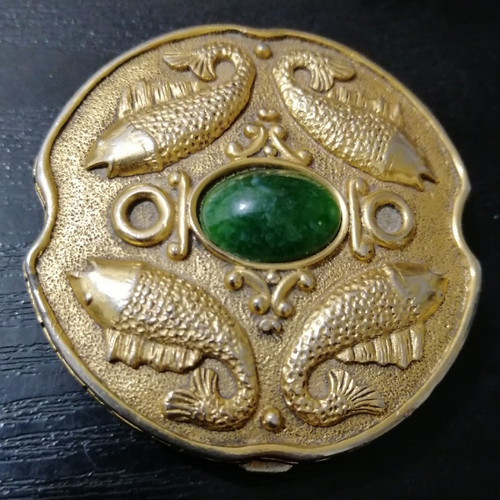 Vintage powder compact used with mirror and gold-plated box with emerald