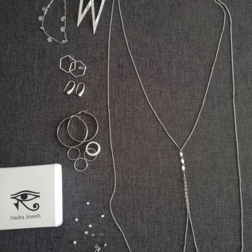 Various silver jewelry including earrings, body chain, rings, and necklace