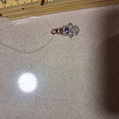 Hamsa pendant with transparent synthetic fishing line used