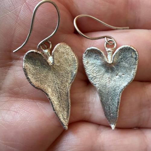 Heart-shaped dangling earrings used, silver color