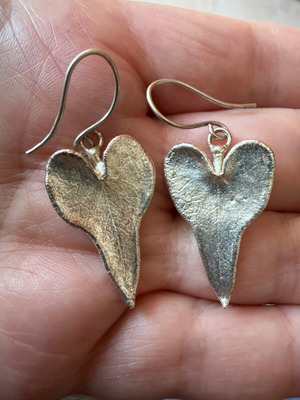 Heart-shaped dangling earrings used, silver color