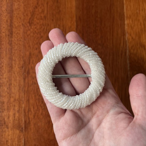 Belt buckle with small white beads