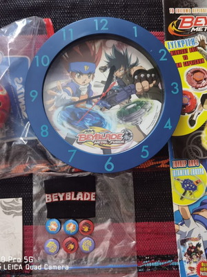 Beyblade collectibles set used with clock, ball, bottle, magazines, and score block