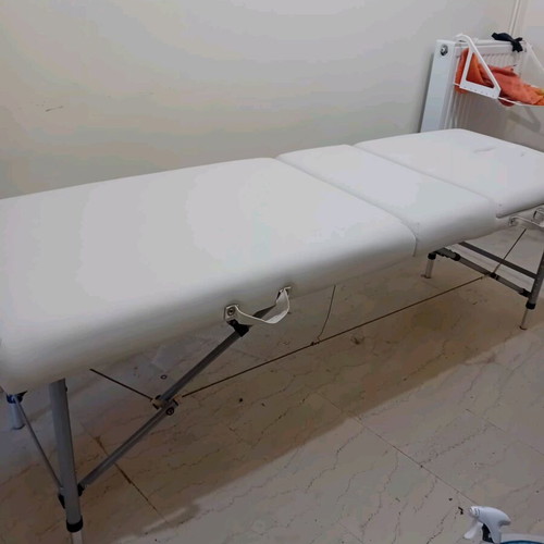 Massage bed like new, white with nickel base and folding feature