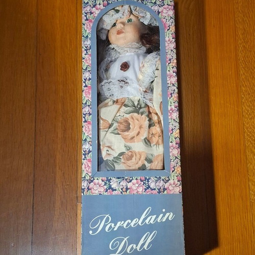 Porcelain collectible doll with brown curly hair and vintage dress, new
