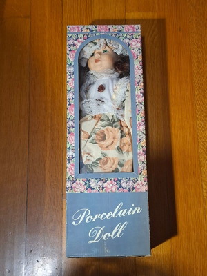 Porcelain collectible doll with brown curly hair and vintage dress, new