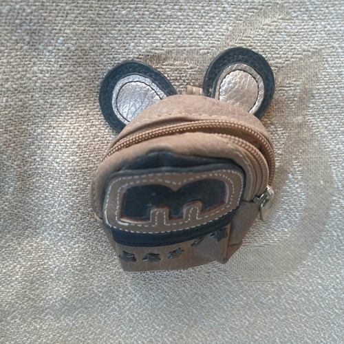 Coin purse used in mini backpack shape with decorative ears and letter M