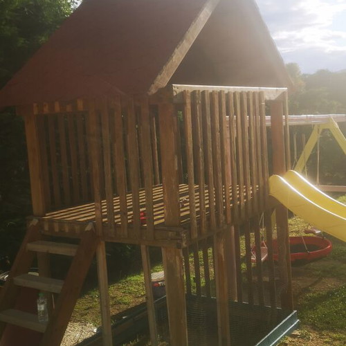 Playground set used with trampoline, seesaw, slide, and swings