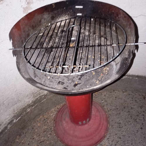 Portable vintage charcoal barbecue with red central leg, used
