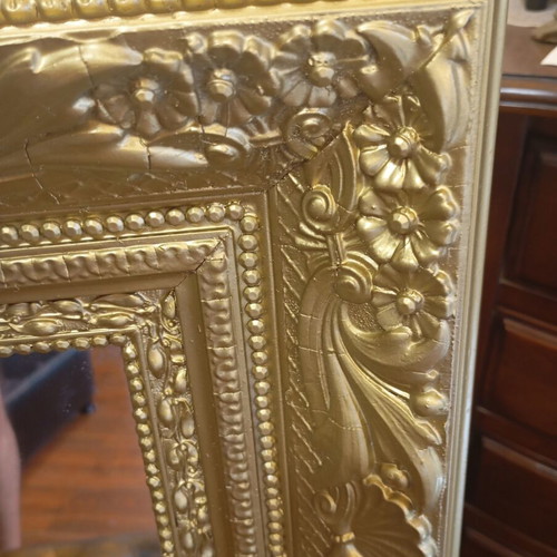 Baroque wall mirror with carved gold frame and embossed motifs