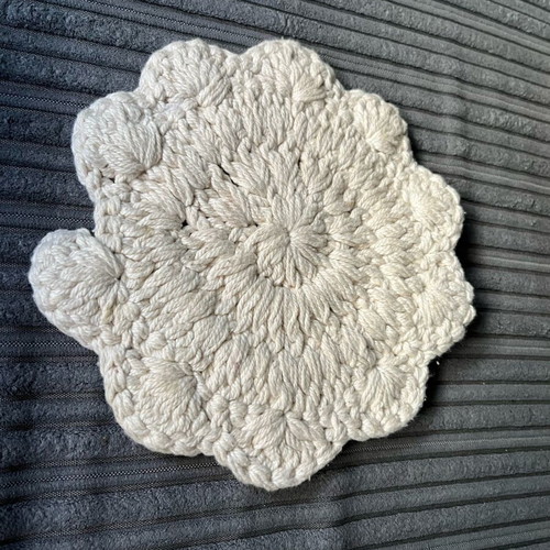 Knitted coaster used, flower-shaped, beige