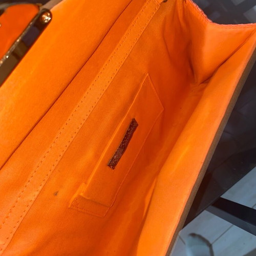 Orange hand clutch bag used with light wear