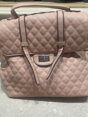 Backpack bag in nude pink with quilted design and metal clasp