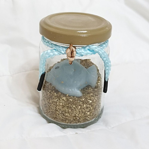 Decorative jar with candle fish and golden sand