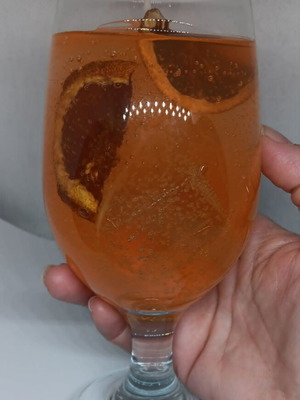 Handmade candle in Aperol Spritz glass with Aperol Spritz scent