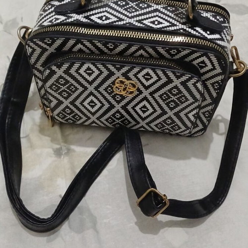 Black and white handbag with dual zipper and spacious interior
