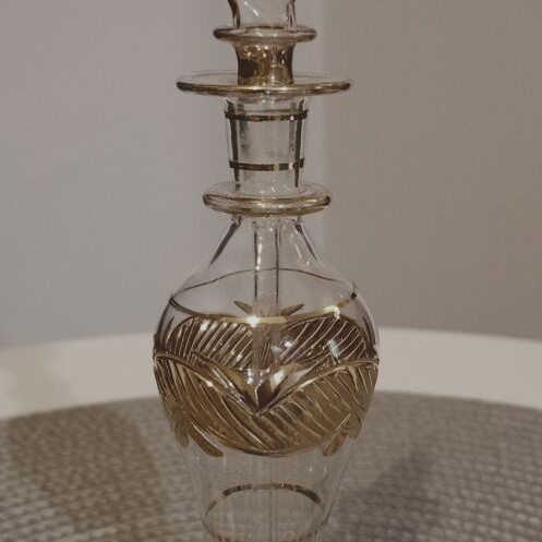 Glass perfume bottle used with golden accents and cap