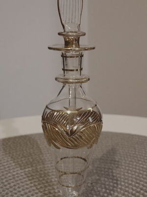 Glass perfume bottle used with golden accents and cap