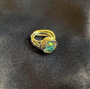 Ασημένιο δαχτυλίδι μεσαίου μεγέθους με χρυσό λεπτό σύρμα και γαλάζιο κρύσταλλο.
