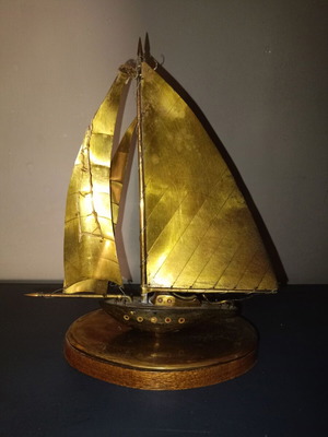 Vintage brass sailboat sculpture on wooden base, used