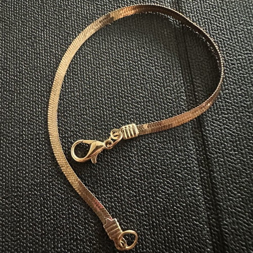 Gold plated bracelet snake chain herringbone style, worn with oxidation spots