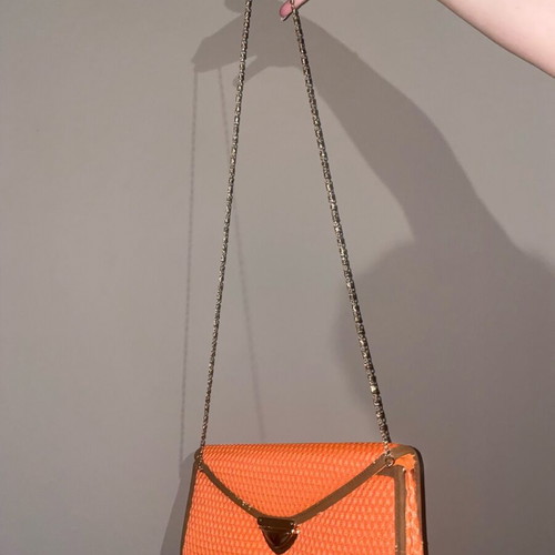Orange hand clutch bag used with light wear